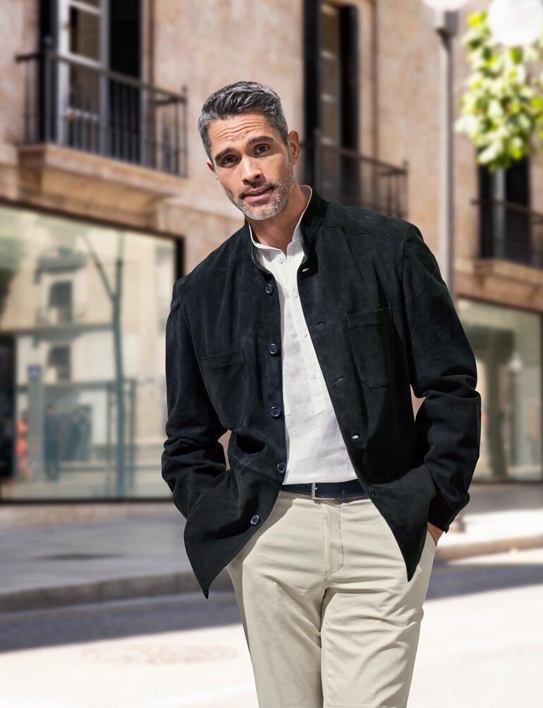 Man in een zwarte rendierkalfsleder hemdjack, toont een ontspannen outfit in een stedelijke omgeving.