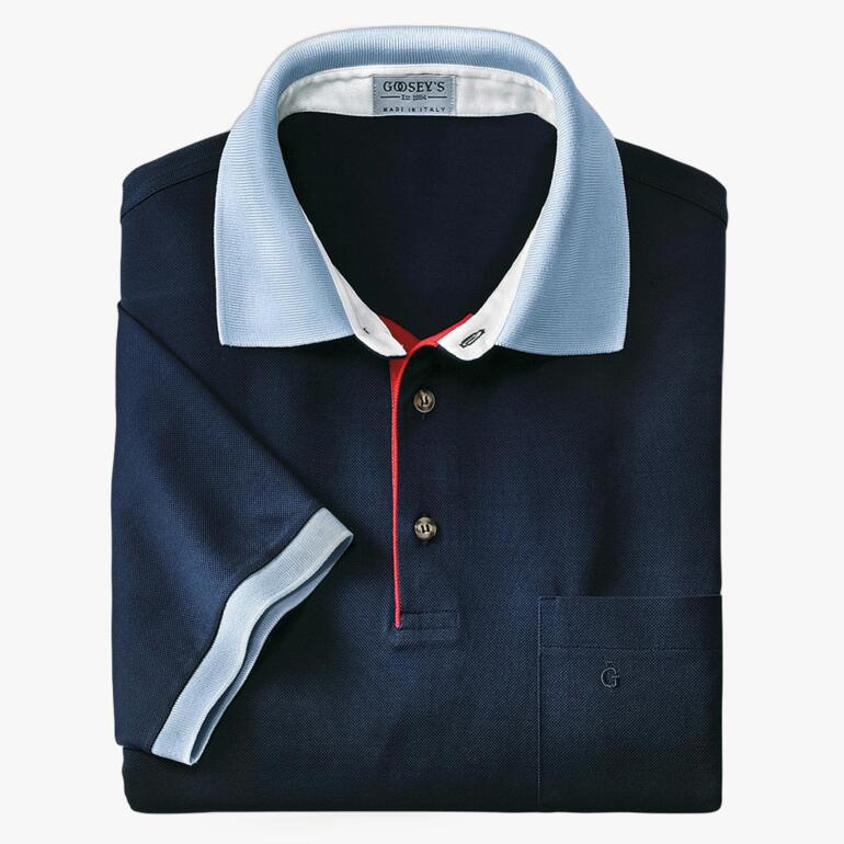 Donkerblau polo met lichte blauwe kraag, gevouwen op een witte achtergrond.