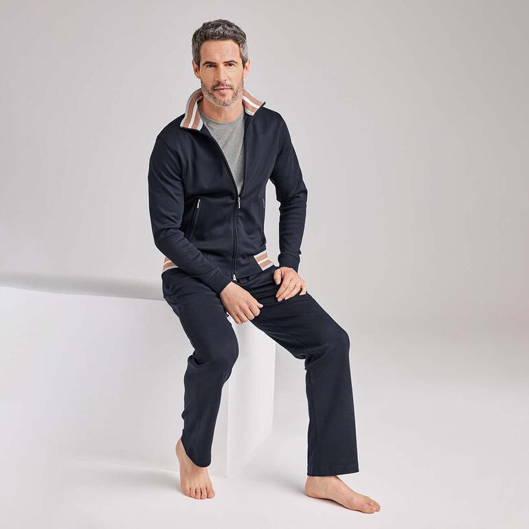 Man in marineblau, zit op de grond in casual kleding.