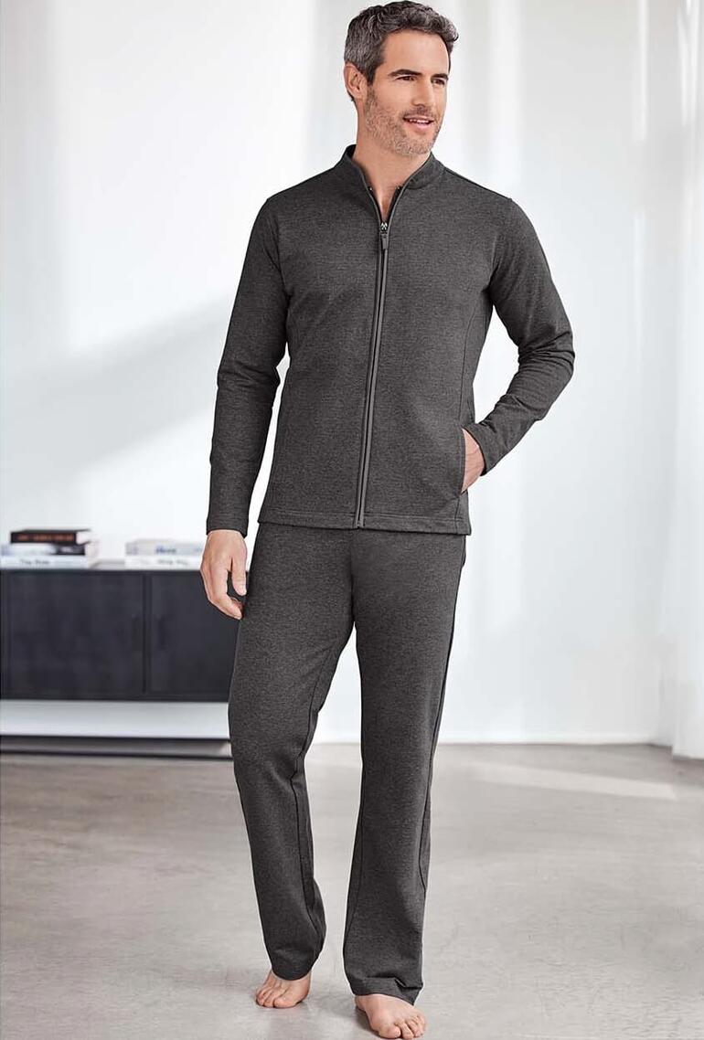Man draagt een grijs loungewear-pak met jack en broek.