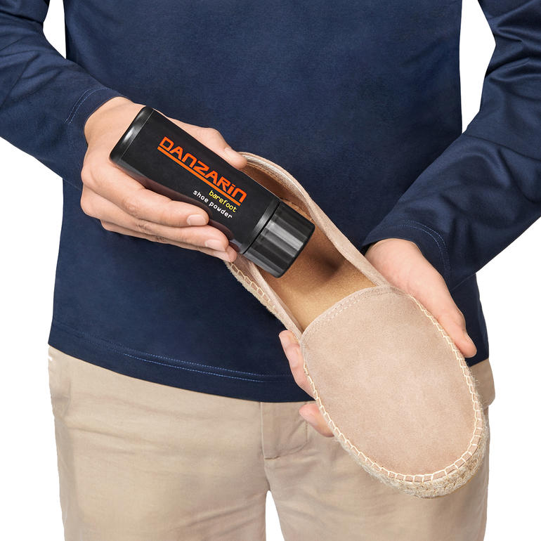 Danzarin schoenpoeder in de hand van een man, klaar voor gebruik op een schoen.