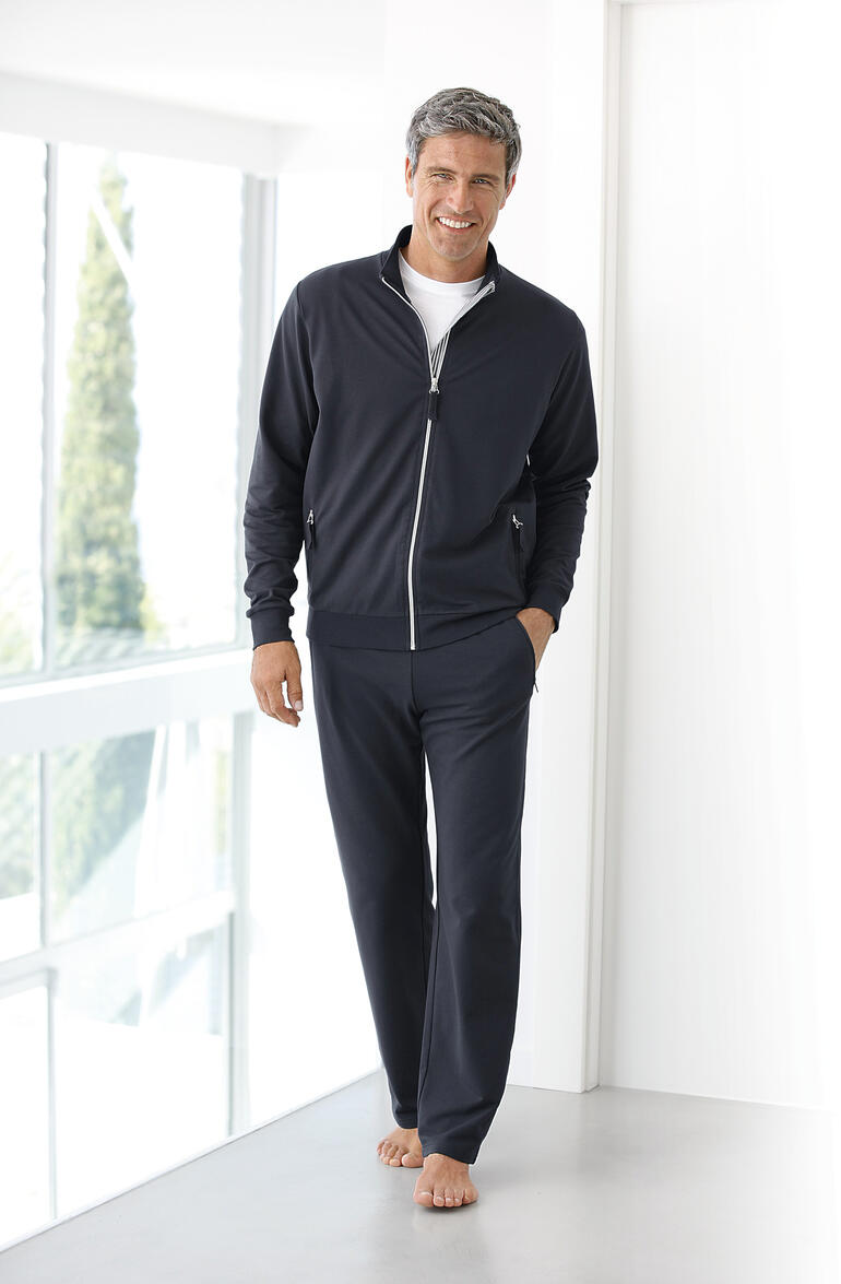 Coolmax®-trainingspak Man in donkerblauwe Coolmax-fitnessoutfit, staande op blote voeten in een lichte omgeving.