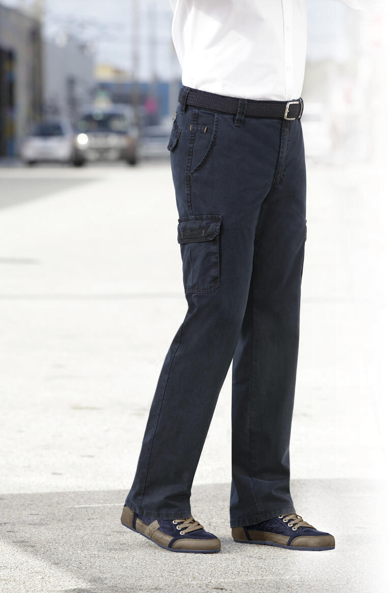 navy Man in donkere cargo-broek, staande in een stedelijke omgeving met een riem.