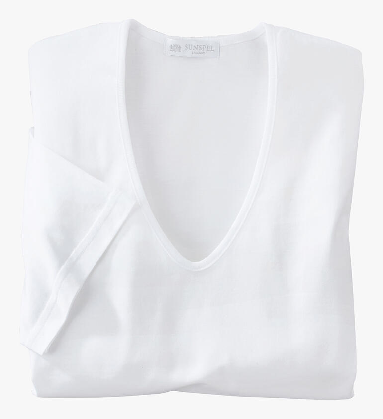 Wit Sunspel-shirt ligt gevouwen op een tafel.