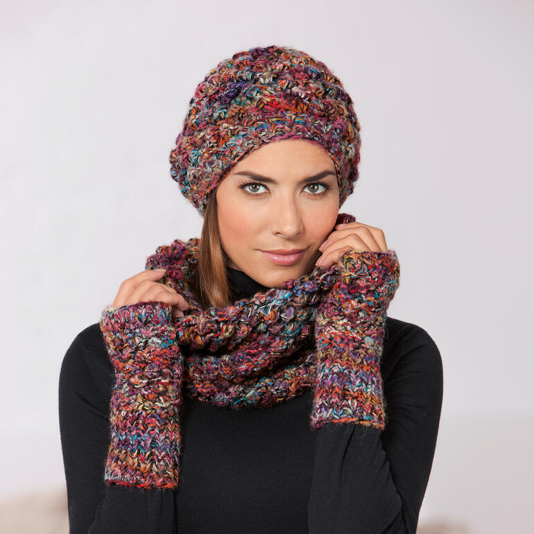 Vrouw draagt een kleurrijke Kero Design Doornroosje beanie met bijpassende vingerloze handschoenen.