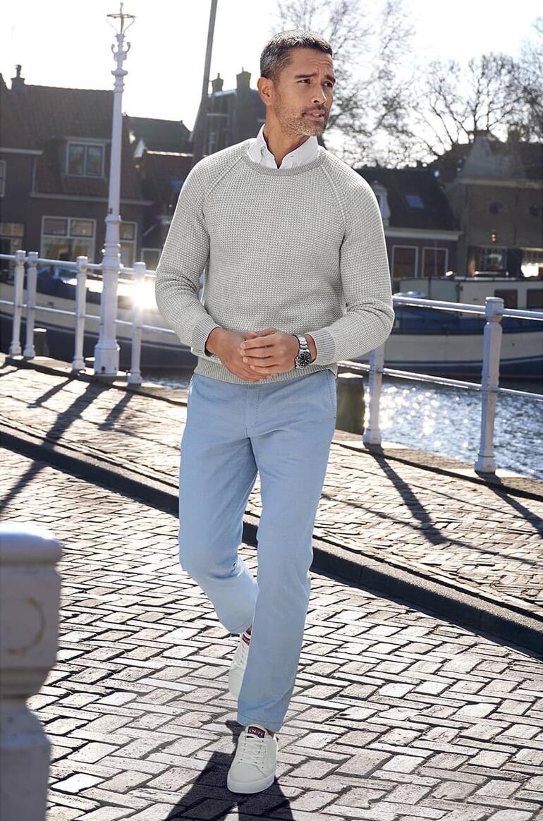 Man draagt een grijze Carbery patent breipullover aan een kanaal.