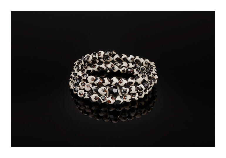 Langani Tibet-Achat-armband met kralen in verschillende kleuren op een zwarte achtergrond.