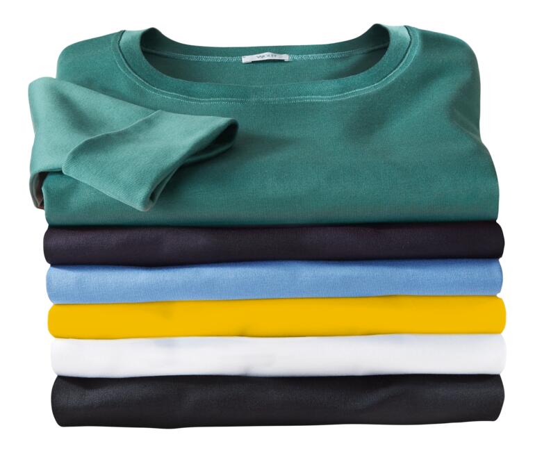 Stapeling van meerkleurige Wolff-shirts op een neutrale achtergrond