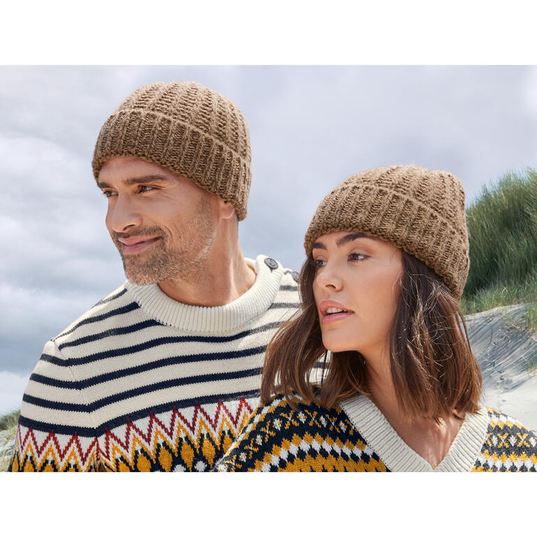 Fisherman-muts van kameelhaar Man en vrouw beide met een bruine Fisherman-kamellenmuts.