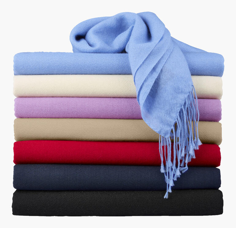 Kleurrijk gestapelde Pashmina-sjaals met een blauwe sjaal bovenop.