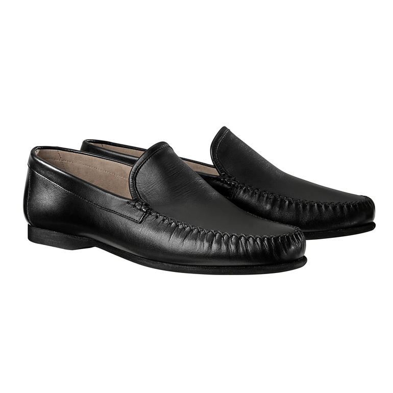 Een paar zwarte mocassinschoenen op een witte achtergrond.