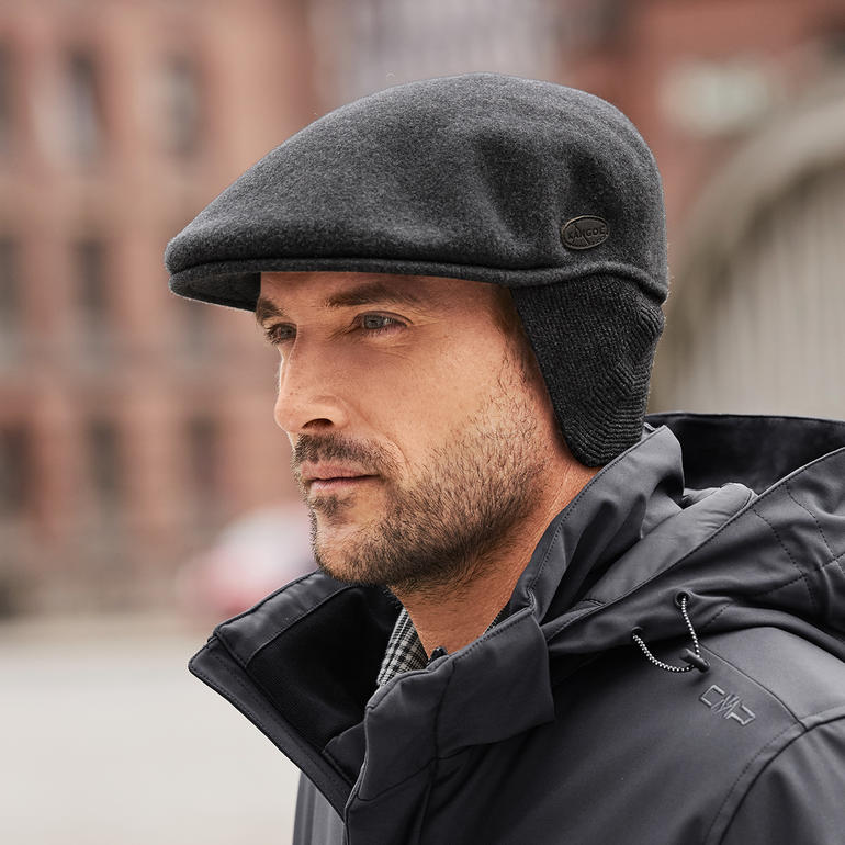 Zij-aanzicht van een man in een Kangol-pet met oorkleppen.