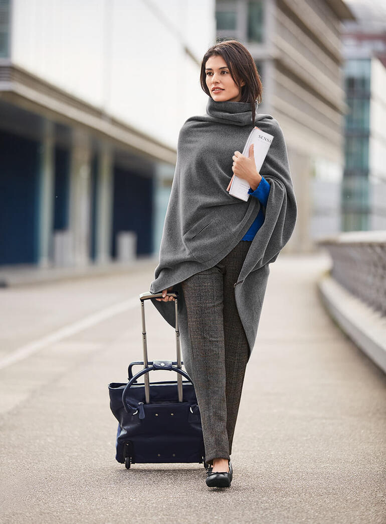 grijs/zwart/bruin Vrouw in een grijze sjaal en glencheck broek met bagage