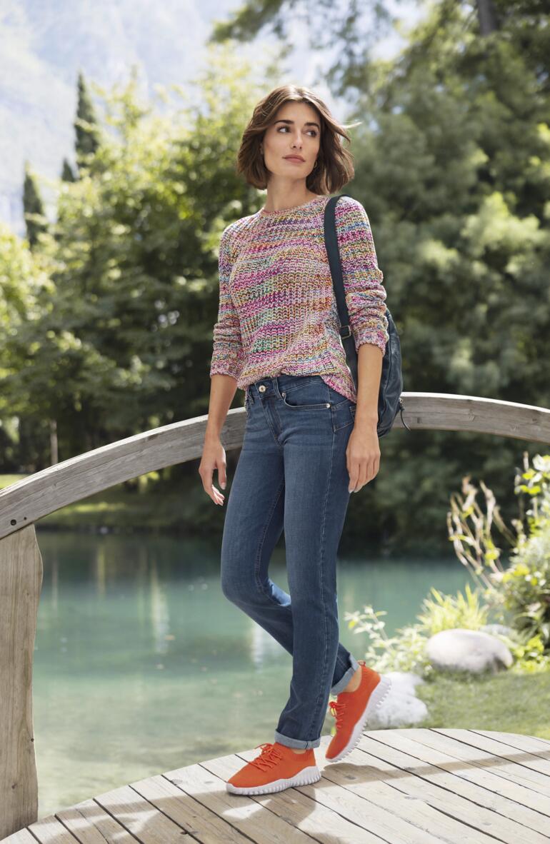 Liu Jo Skinny-fit jeans Bottom up Vrouw in een kleurrijke katoen trui op een houten brug met een idyllische achtergrond.
