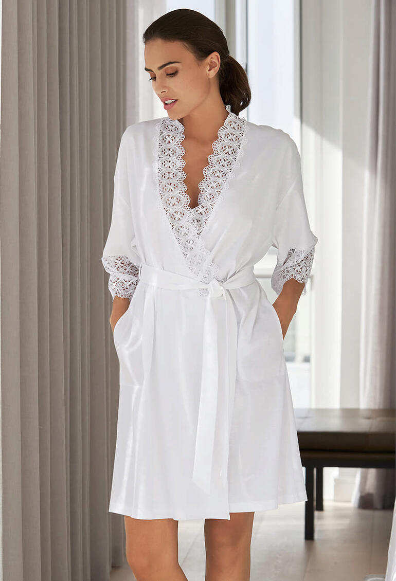 Vrouw in een witte kanten kimono met een strikceintuur