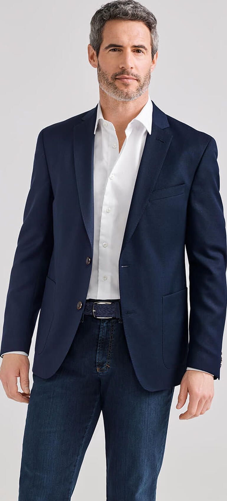 blauw Man in donker reiscasual jacket met wit overhemd, casual houding.