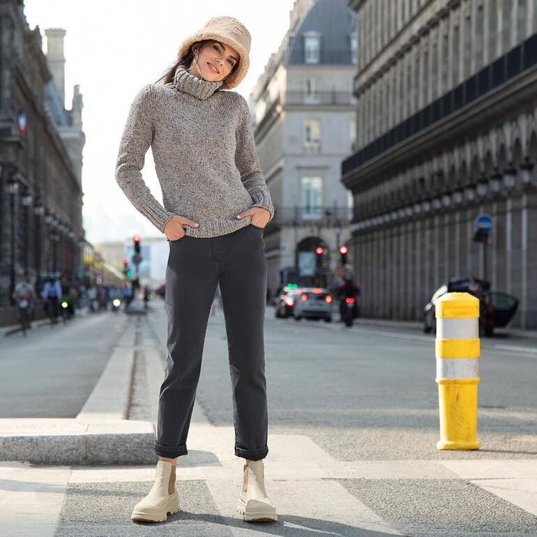 Werner chunky Chelsea-boots Vrouw in grijze trui en bucket hat op straat.