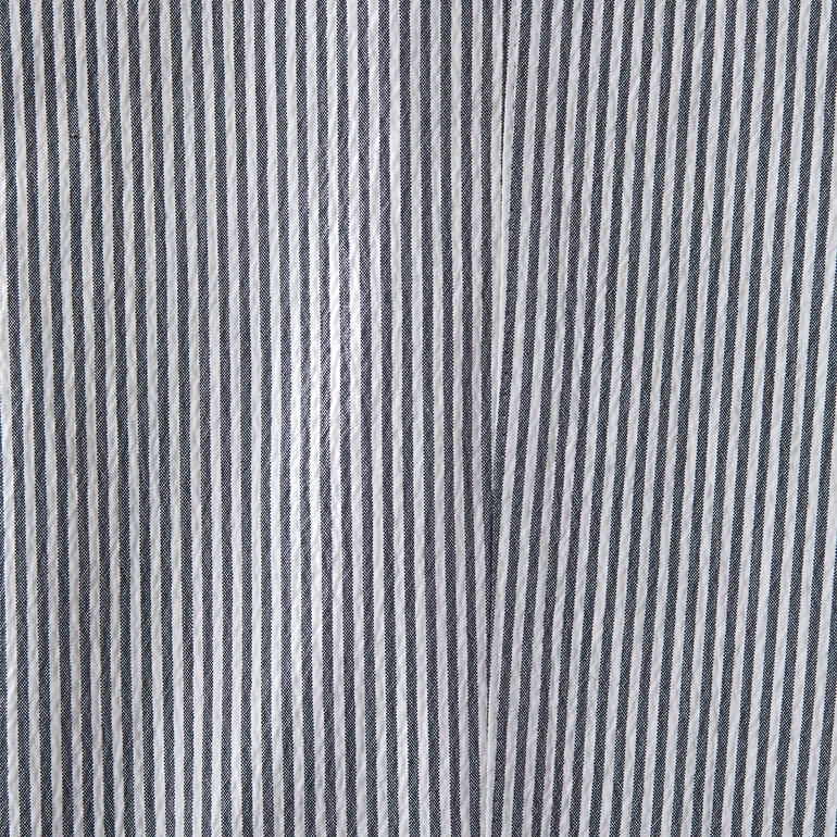 wit/blauw Close-up van de stof van een seersucker broek met gestreept patroon