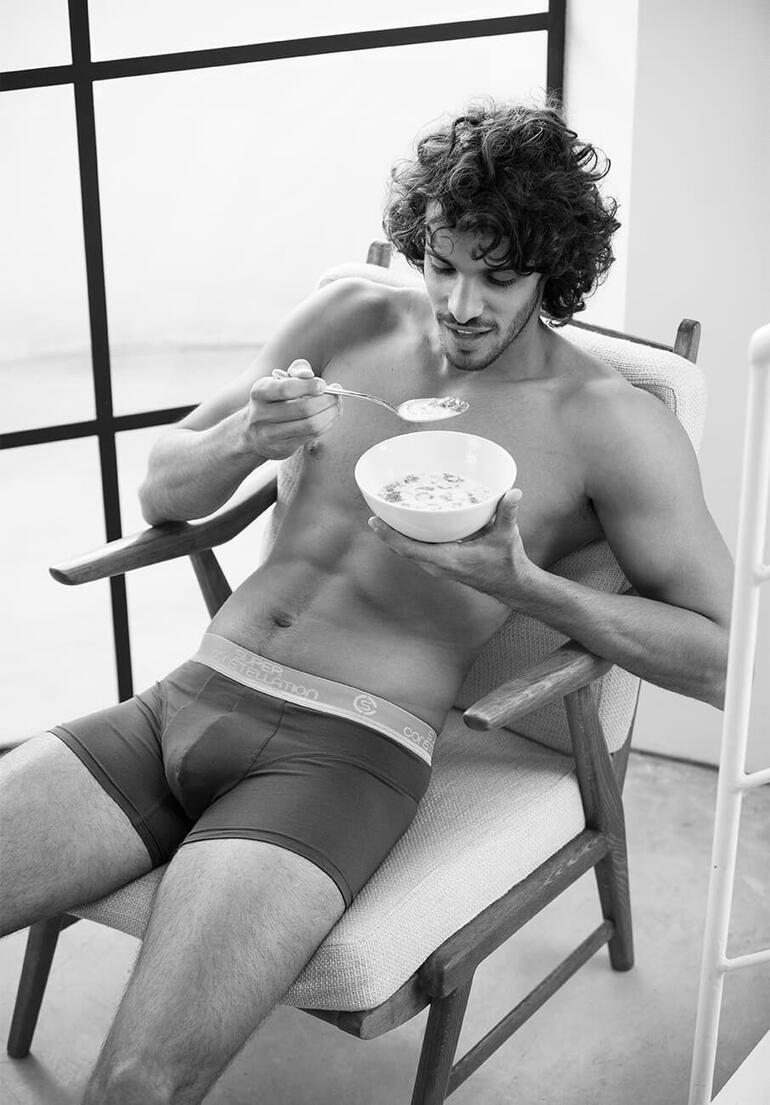 short, grijs Man in boxershorts, ontbijt met een kom ontbijtgranen.