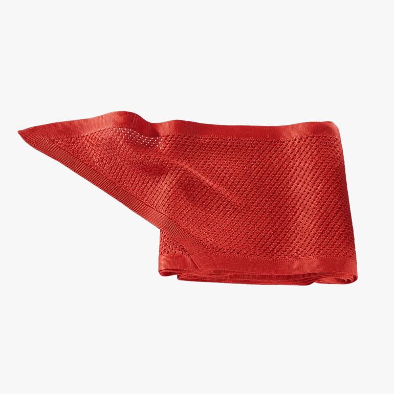 Gehaakte rode zijden sjaal op een witte achtergrond.