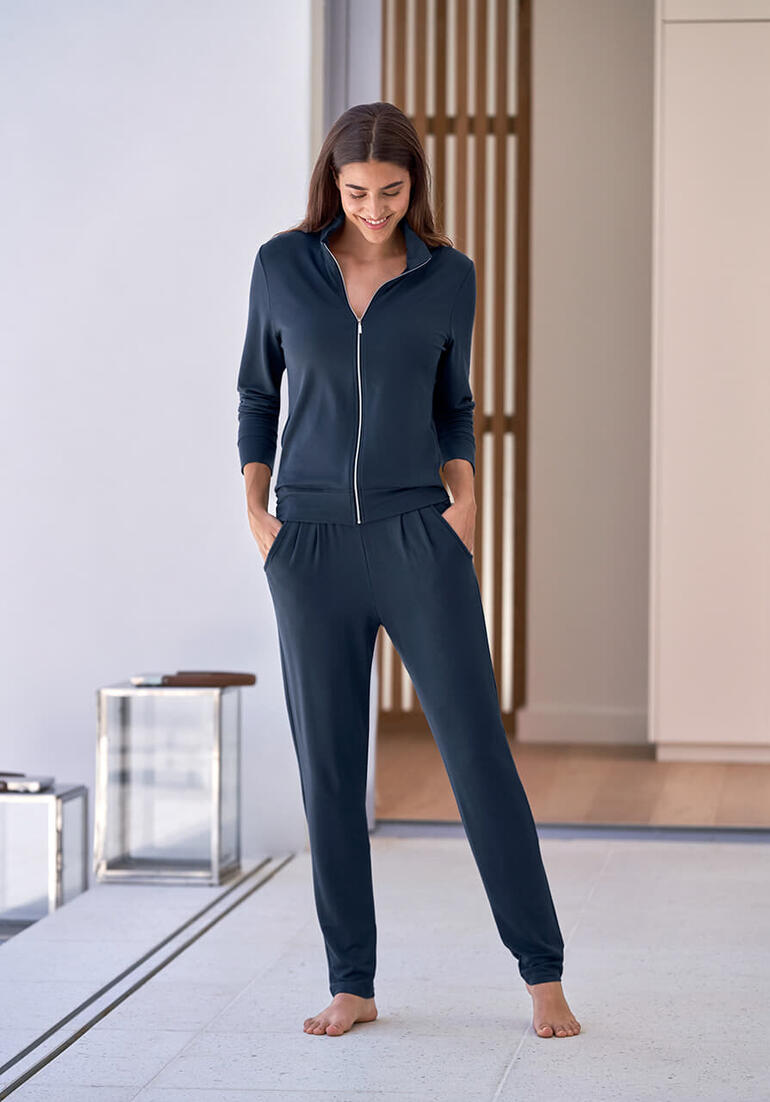 saffier blauw Vrouw in donkerblauwe modal huispak met rits staat in moderne ruimte.