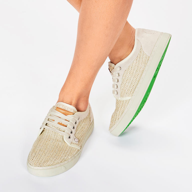 Beige gevlochten sneakers met groene zool en veters.