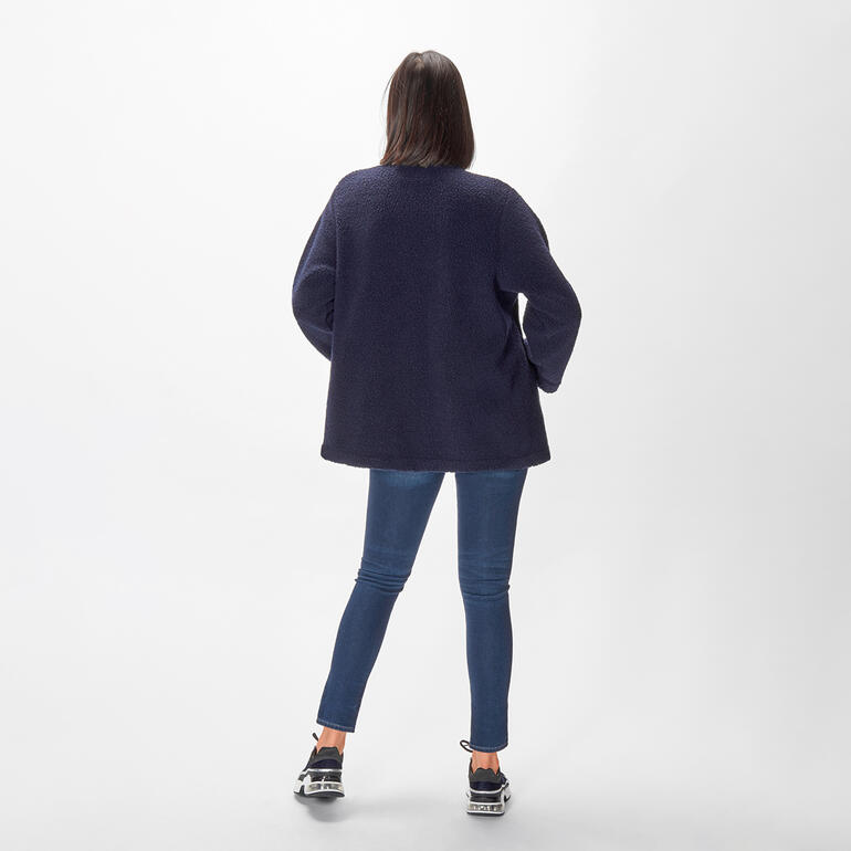 boucléjasje Donkerblau bouclé jasje van achteren, gedragen door een vrouw in jeans.