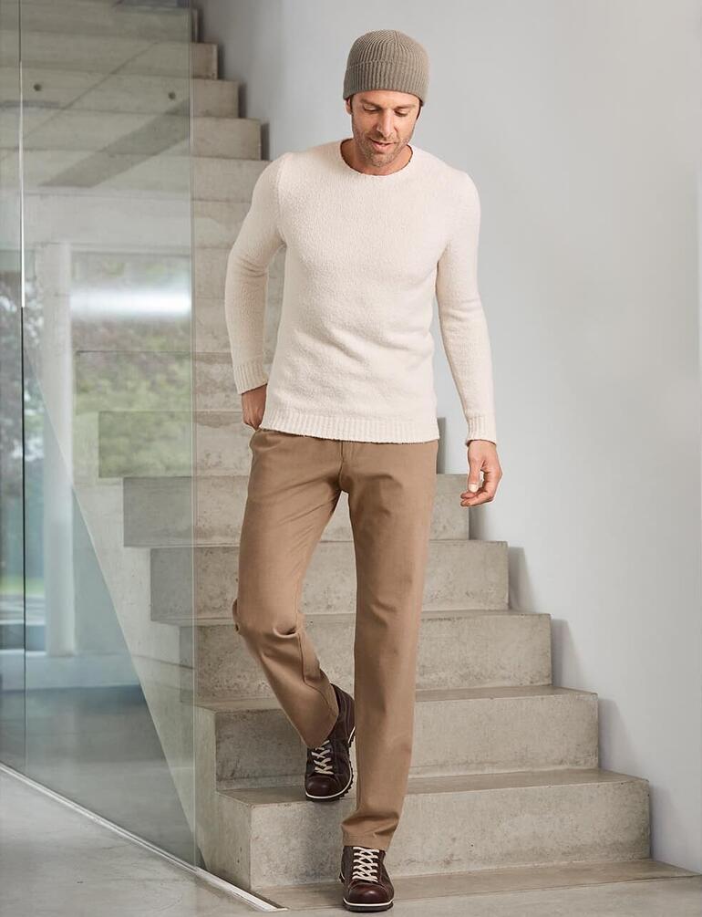 beige Man draagt Snipe® Ripple leren sneakers met beige broek en een lichte trui