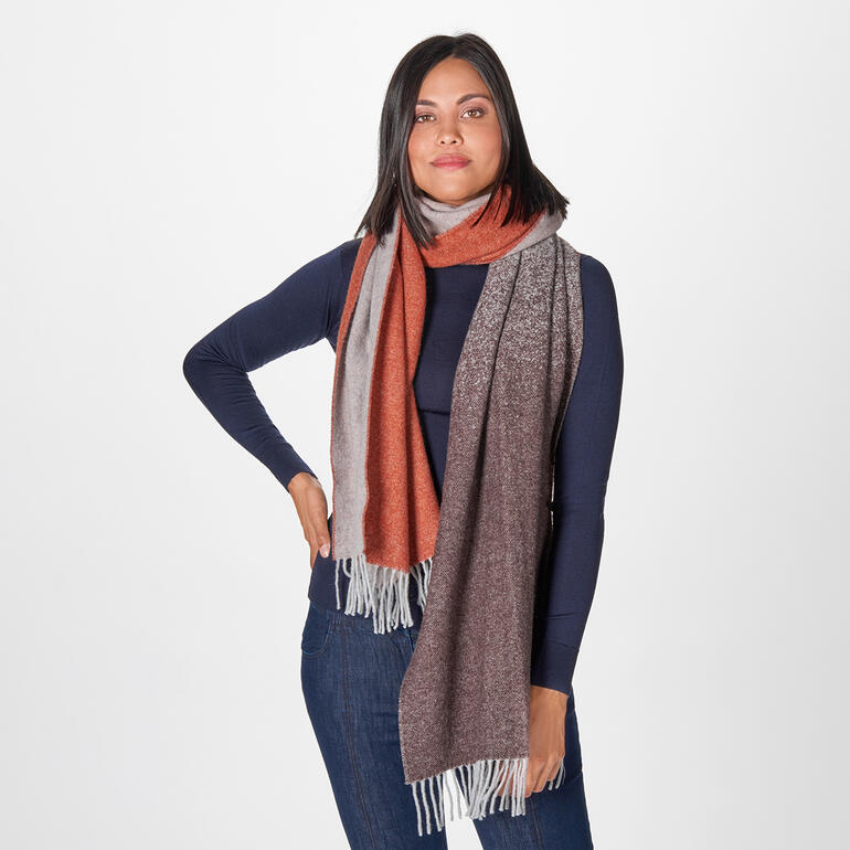 rood/bruin/grijs Vrouw draagt een jacquard-sjaal in rood- en grijstinten.