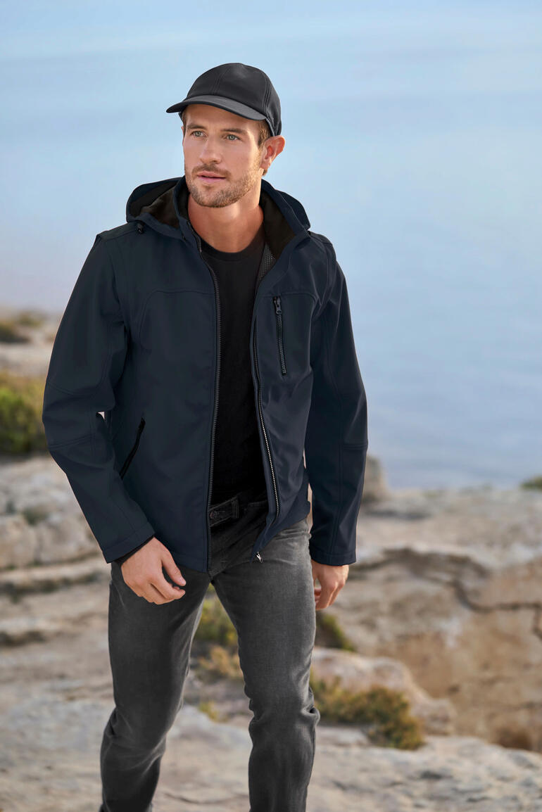 heren, navy Man in een zwarte softshell-jack aan zee.