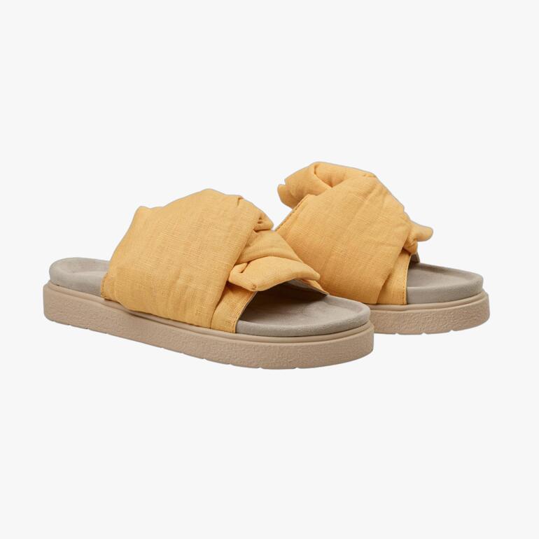 Geel knoop-slipper van Inuikii, zijaanzicht op een neutrale achtergrond.