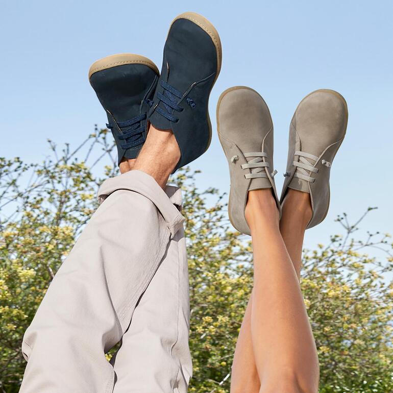 Voeten in zwarte en grijze Snipe® barefoot leren schoenen, informele achtergrond