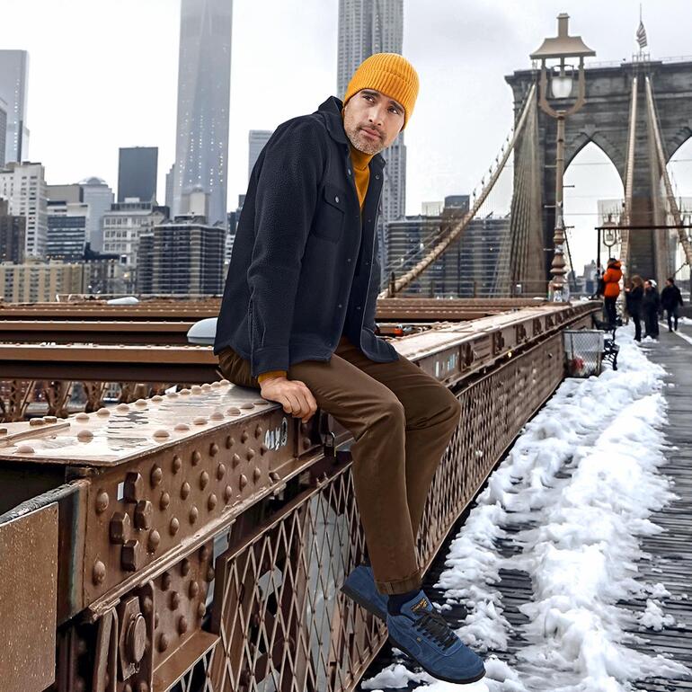 Man in Aigle teddy-fleece overshirt op een brug