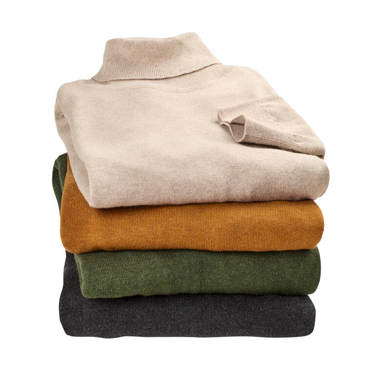 Stapeltje fijngebreide coltruien in verschillende kleuren.