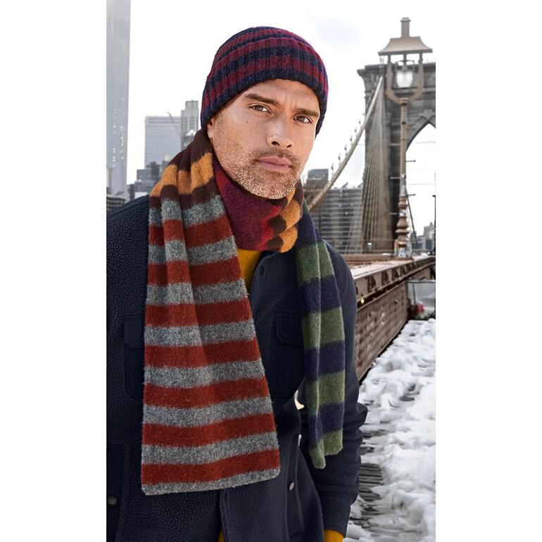 muts en sjaal Man in gestreepte sjaal en bijpassende muts, staat voor de Brooklyn Bridge.
