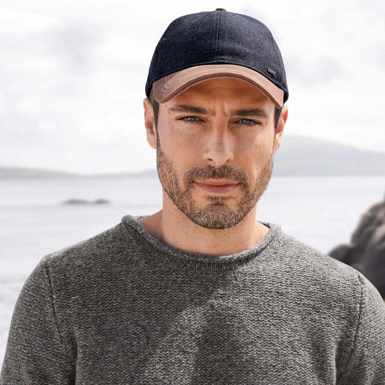 Leer-tweed pet, navy Man draagt navy leren tweedcap aan het strand.