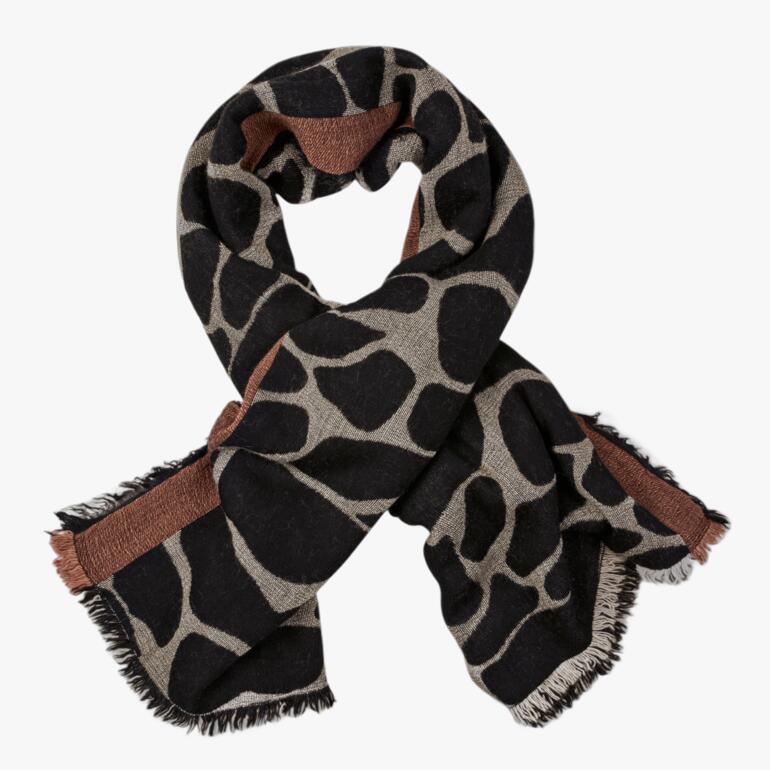 Wende-poncho met giraffenpatroon in zwart en beige, losjes gedrapeerd.