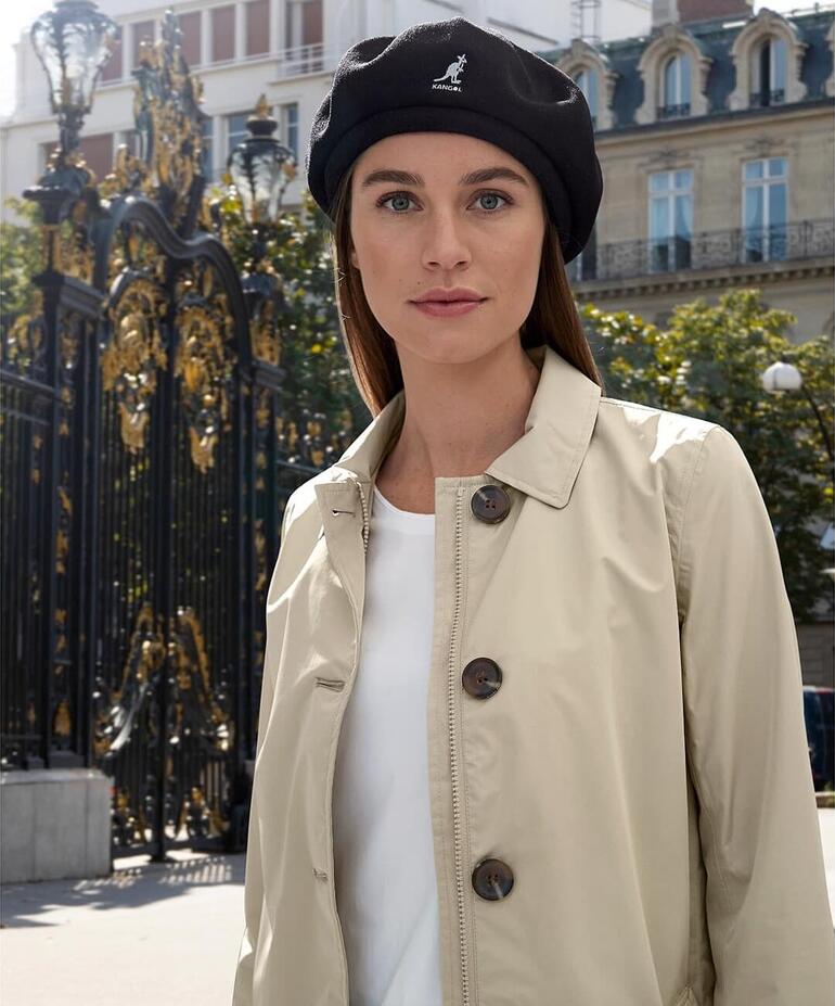 zwart Vrouw met Kangol bamboe baret en beige blazer in stedelijke omgeving.