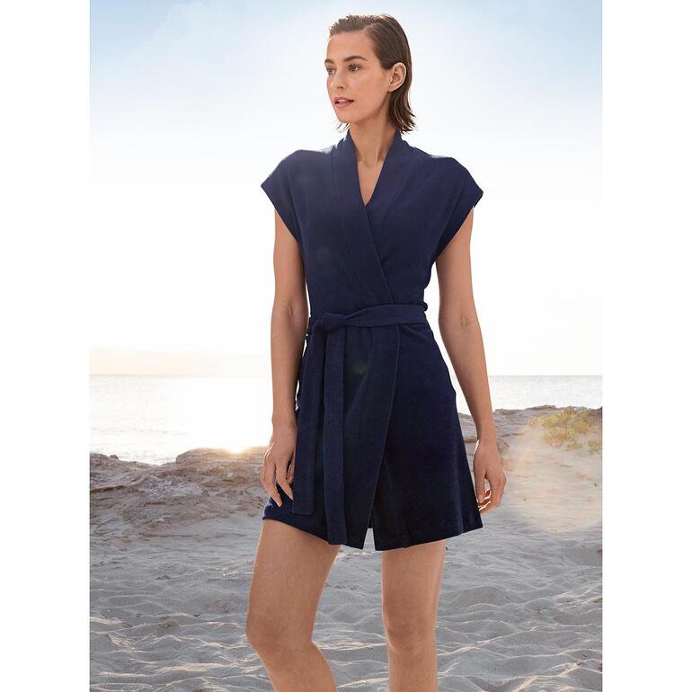 jas en bermuda Donkerblauwe badjas van terry, gedragen door een vrouw op het strand.