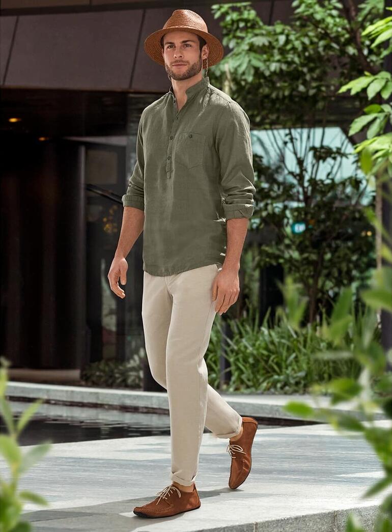Sole Runner® leren mocassins Man in leren mocassins met een casual outfit staat in een groene omgeving.