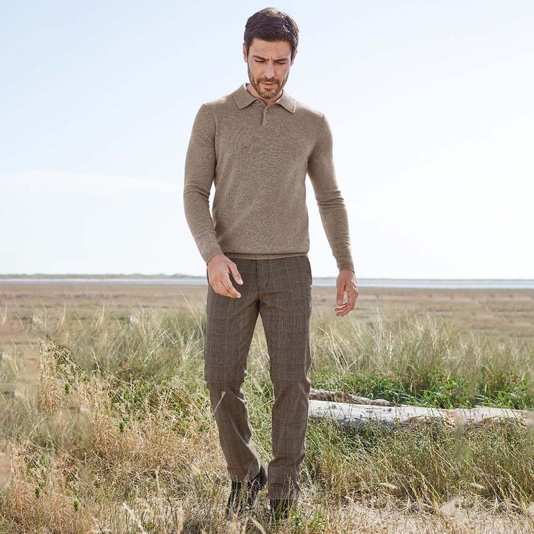 Man in casual Glencheck-broek en trui, die in de natuur is.