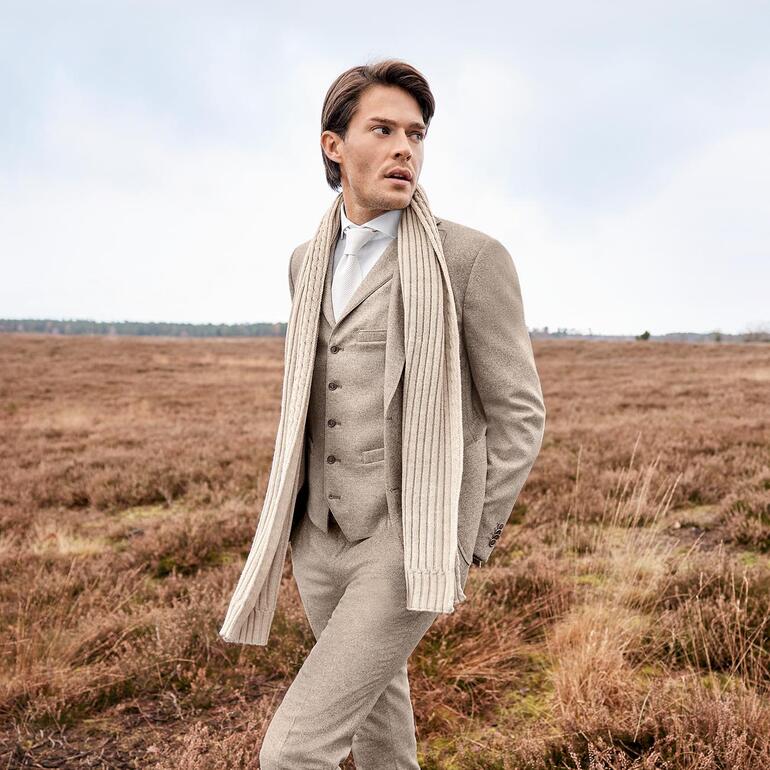 colbert, gilet en broek Man in soft donegal jasje met sjaal in de buitenlucht.