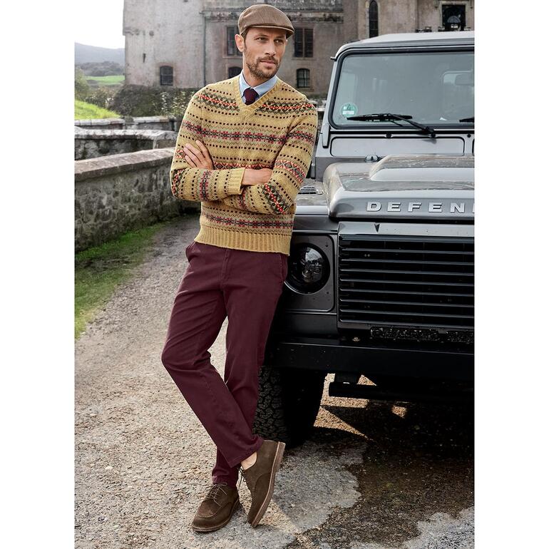 Fair Isle-trui met V-hals Edward Man in Fair-Isle-V-pullover Edward staat naast een terreinwagen.