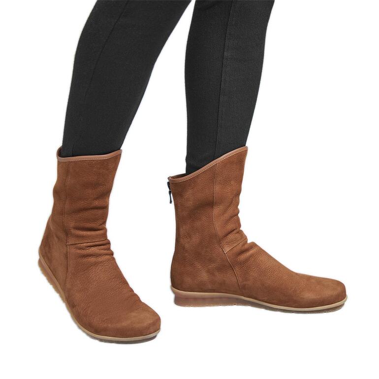 arche stierenleren laarsjes Bruine arche stierenleer laars, casual aan de voet van een persoon met zwarte leggings.