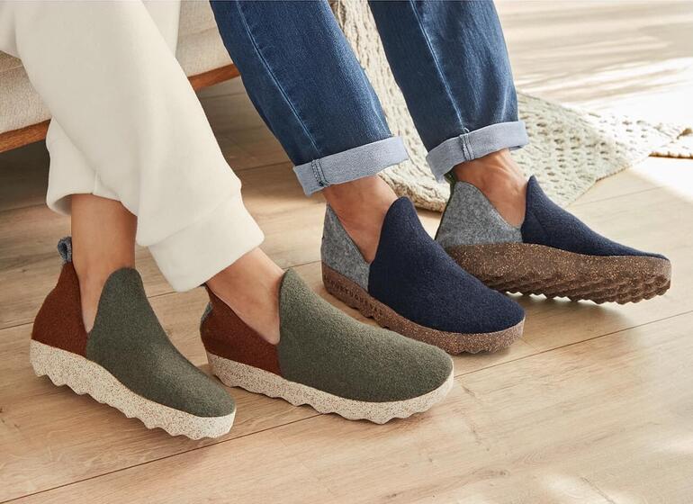 dames, groen/rood en heren, navy/grijs Twee paar sneaker-slippers in verschillende kleuren naast elkaar op de grond.