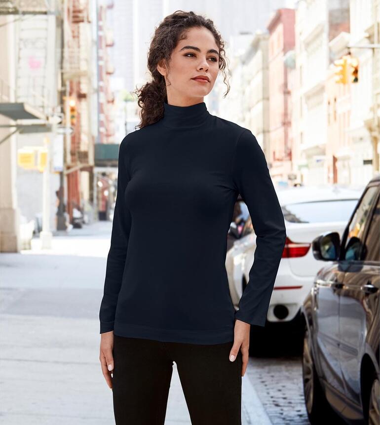 Vrouw in zwart katoen/kasjmier highneck-shirt op straat.