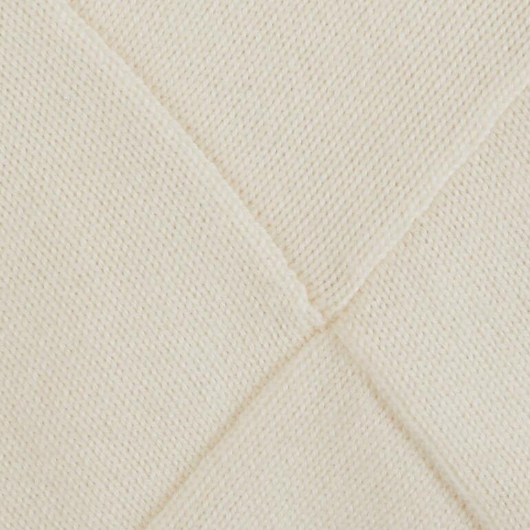 Close-up van een lichtgele trui met diagonaal breipatroon.