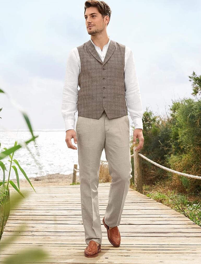 Carl Gross vest van wol/linnen Man in een wol-linnen vest staat op een houten loopbrug aan de zee.