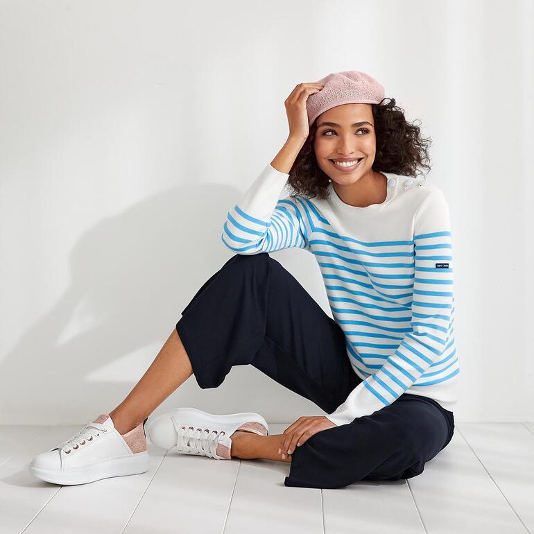 Vrouw in een gestreept shirt, zit op de grond naast een fiets