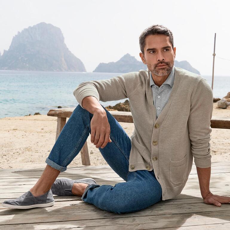 Carbery linnen-vest Man in beige linnen cardigan zittend op het strand
